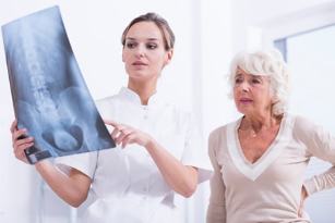 дәрігер көрсетеді пациентке рентген суретін омыртқа